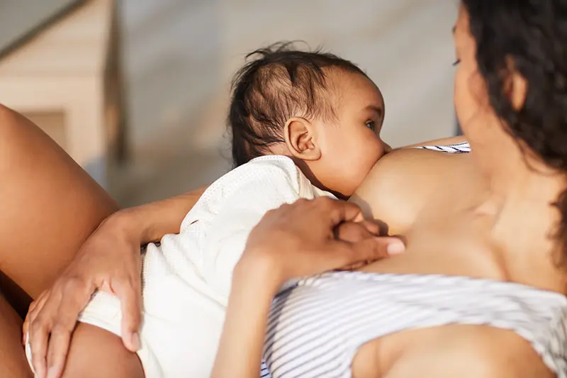 Ein Baby beim stillen an der Brust seiner Mutter